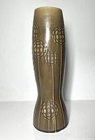 Front view of the tall ceramic vase showing embossed floral pattern and overall shape and glaze finish.