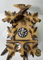 Front view showing carved leaf motifs, bird finial and overall condition