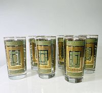 Photo showing six vintage highball glasses with green and gold rectangular geometric and floral panels, arranged in two rows.