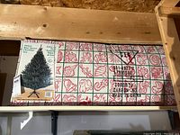 Photo showing the boxed artificial blue spruce Christmas tree with a picture of the tree and decorative holiday themed box design.