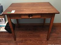 Front view of the wood desk showing center drawer and surface wear