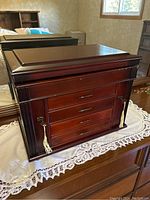 Front view of the wood veneer jewellery box showing 4 drawers, keyholes with tassel keys and polished finish.