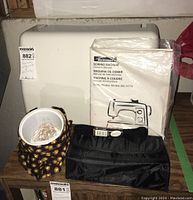 Kenmore sewing machine hard white carrying case with owner's manual, black fabric pouch, and coil of thread