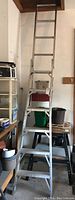 Full view of the aluminum ladder set up in the step ladder configuration in a garage space.