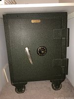 Full front view of McCaskey safe with door closed showing handle, combination dial lock, and brand nameplate.