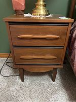 Front view of wooden night stand with two drawers and visible scratches on surface.