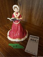 Full view of the Royal Doulton figurine standing on a wooden surface with a measurement label of 6.5 inches next to it.