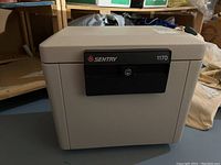 Sentry Safe model 1170 in beige with black locking mechanism shown from an angle.