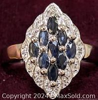 Front view showing marquise cut dark blue sapphires surrounded by white topaz stones in a marquise cluster design on the sterling silver band.