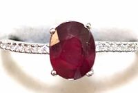 Close-up photo of the sterling silver ring showing the large oval ruby gemstone and the cubic zirconia stones along the band.