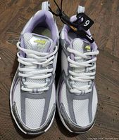 Front view of new women's size 9 Nike athletic shoes with white mesh, silver, and lavender accents.