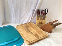 Two turquoise plastic cutting boards and wood cutting board laid flat