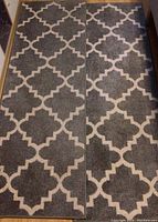 Pair of gray and white runner rugs side by side on floor, showing full length and pattern