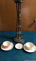 Overall shot of Space Needle ashtray, cups, saucers, and plate on blue surface