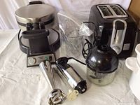 Wide view showing all included appliances: Waring waffle maker, Cuisinart immersion blender attachments, toaster, slow cooker, and chopper attachment