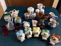 All small pitchers, creamers, sugar bowls placed on table showing variety and quantity.