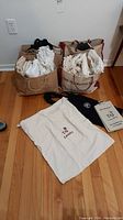 Photo of large and medium canvas bags filled and placed on the floor, showing shape and size of the assorted bags.