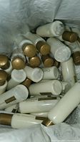 Plastic bag filled with white bottles with gold caps labeled CHAMARIUM Cosmetique Lotion