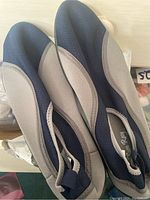 Pair of men's water shoes showing top/side view in black and gray with slip-on design and pull tab at heel.