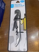 Front view of new silver-colored waiter’s corkscrew still attached to packaging card