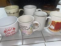 Group photo of six assorted mugs, showing different designs and colors