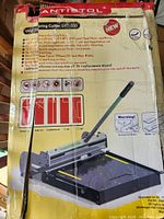 Box of Antistol LVT-330 Vinyl Flooring Cutter with product information and safety warnings visible on label.