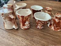 Front angle view of all eight ceramic cups showing two main styles and the marbled glaze for each.