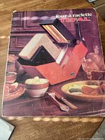 Original box with photo of the Tefal Four à Raclette cheese warmer showing vintage appliance on table with food.