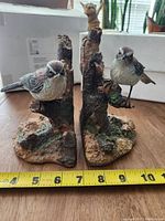 Pair of sparrow bird bookends showing front and side views with measuring tape indicating size.
