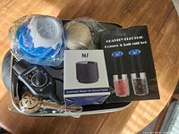 Photo of various kitchen gadgets including electric skillet lid, vacuum sealer, salt and pepper mills, powdered sugar shaker, egg separator, and measuring cups