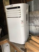 Front and angled views of Danby portable air conditioner showing air vents, control panel side, and power cord.