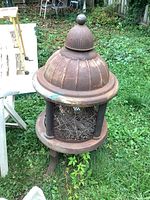 Top and side view showing domed cap with finial, mesh sides and three legs resting on grass lawn