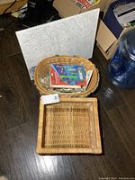 Overall view showing square and round baskets, paint-by-numbers canvas board leaned against wall, and craft tool pack inside round basket.