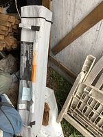 Full view of the gray carrying bag holding the folded gazebo with a label visible.