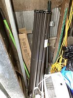 Folded metal frame of the gazebo stored vertically showing structure and frame length.