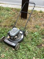 Full view of the Murray push lawn mower on grass, showing the handle, wheels, and mower body.