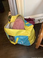 Extra-large yellow and blue tote bag filled with large balls of yarn, showing the overall contents of the bag.