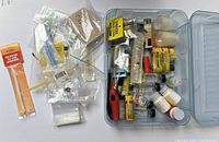 Full overview of entire lot including plastic box and loose packaging with tying materials and small bottles