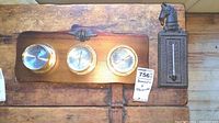Overview of both Springfield triple barometer and cast iron thermometer on wooden surface.