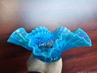 Angled side view showing ruffled edges and textured glass pattern.