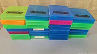 Stack of 27 colorful Nintendo game cases arranged side by side displaying various colors including green, blue, orange and pink with the Nintendo logo on top.