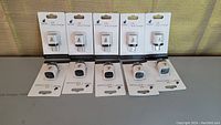 Front view of 10 USB wall chargers in packaging arranged in two rows.