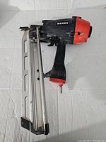 Front and side view of the Banks framing nailer showing the nail magazine, handle, trigger, and air fitting connection.
