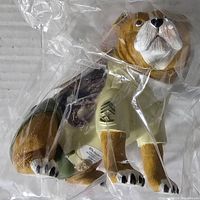 Front angled view of Hamilton Collection dog figurine wearing U.S. Marine Corps shirt inside protective plastic wrapping.
