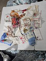 Top-down view of a pile of various vintage handkerchiefs showing diverse floral patterns and colors.