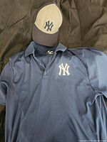 Navy blue New York Yankees Dri-Fit polo shirt and two-tone baseball hat with NY logo
