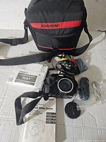 Full lot including Olympus camera, carrying case, user manuals, lens cap, and cables