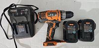 Complete set showing drill, charger and two batteries on white surface