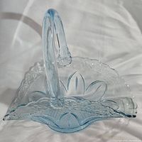 Top view of the light blue brides basket handle and scalloped rim with floral pattern.