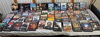 Photo showing full spread of 43 DVDs on a surface, variety of movie titles and cover art visible